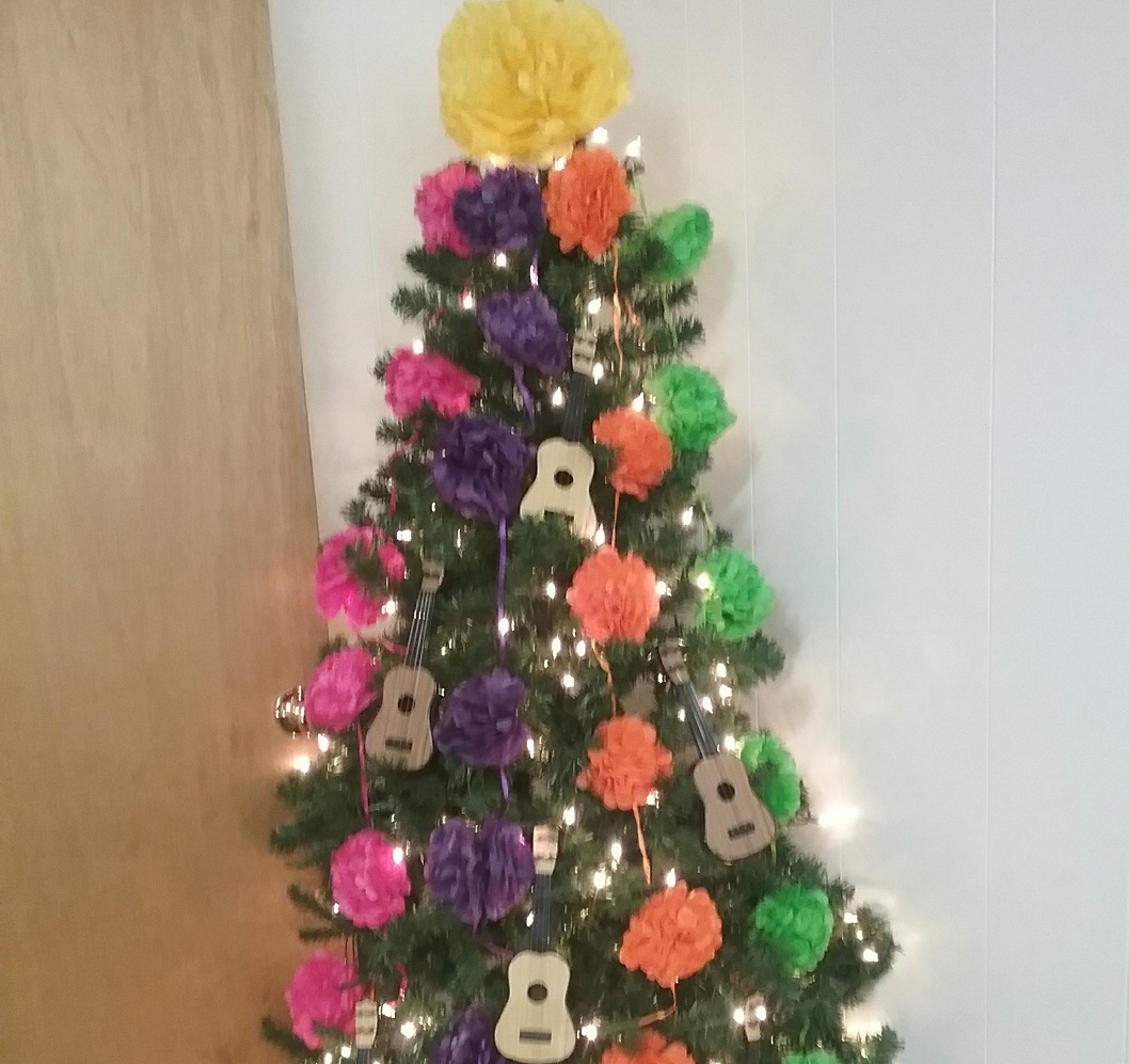 Tree decorated with bright paper flowers and tiny guitars